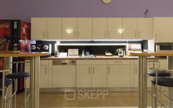 Office space rental available at Kohlmarkt 8-10, 1010 Vienna with a well-equipped kitchenette and casual seating.