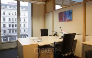 Modern, well-lit office space rental at Kohlmarkt 8-10, 1010 Vienna with a view of the city and contemporary furnishings.