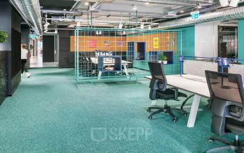 Modern office space rental at Nordbahnstraße 47, 1020 Vienna Leopoldstadt, with vibrant green carpeting and contemporary furnishings.