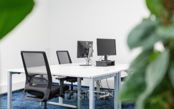 Modern eingerichtetes Büro zum Mieten in der Aspernbrückengasse 2, 1020 Wien Leopoldstadt, mit zwei Arbeitsstationen und eleganter Beleuchtung.