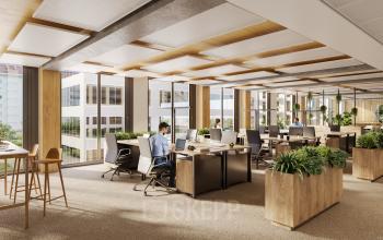 Modernes Büro mit großen Fenstern in 1020 Wien, ideal zum Büroraum mieten. Personen arbeiten konzentriert an Schreibtischen, während Tageslicht den Raum erhellt und Pflanzen ihn beleben.