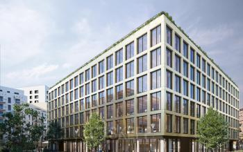 Modernes Bürogebäude in der Oberen Donaustraße 23-29, 1020 Wien, ideal zum Büroraum mieten. Geschäftsleute bewegen sich im Außenbereich, der von Grünflächen umgeben ist.