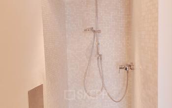 Modern shower facility at Mittersteig 10, 1050 Vienna Margareten office space rental, with elegant beige tiles and sleek fixtures.