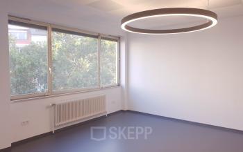 Modern, well-lit office to rent at Mittersteig 10, 1050 Vienna Margareten, with large windows and a contemporary light fixture.