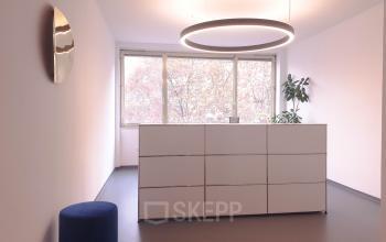 Modern and well-lit office space rental at Mittersteig 10 in 1050 Vienna Margareten with sleek furnishings and large windows offering a serene view.