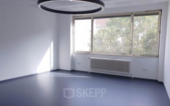 Bright office space rental at Mittersteig 10, 1050 Vienna Margareten with large windows and modern lighting fixtures.