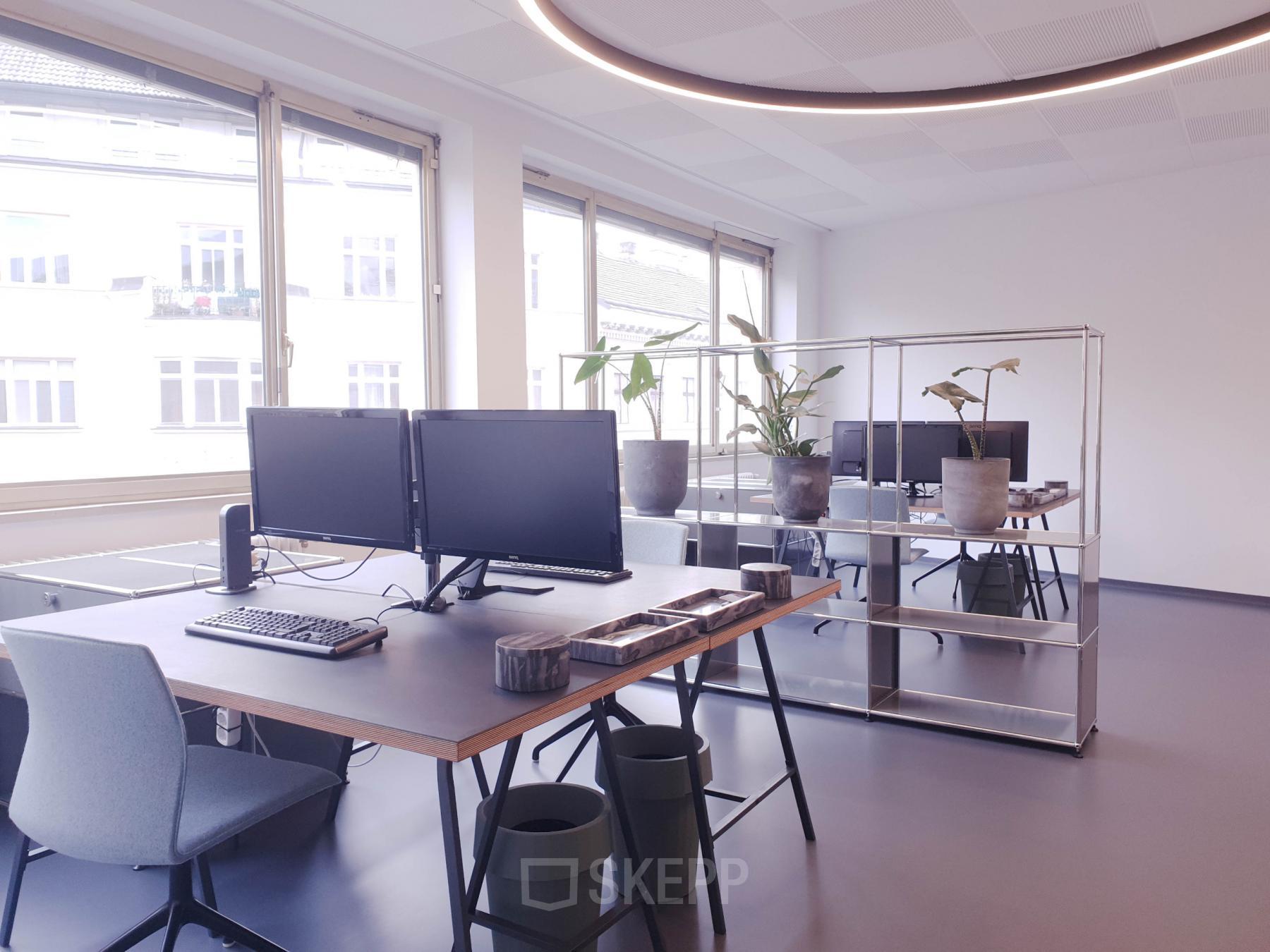 A bright, well-lit office space at Mittersteig 10, 1050 Vienna Margareten with modern desks and computers, ideal for those looking to rent office space.