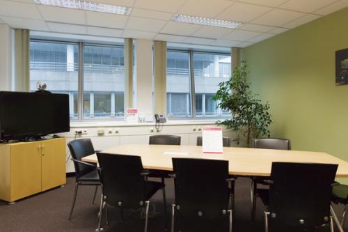 Well-equipped office space rental at Mariahilfer Straße 123, 1060 Vienna Mariahilf, featuring a conference table, chairs, and a TV for presentations.