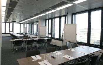 Modernes Büro für Konferenzen mit mehreren Tischen und Stühlen in Am Belvedere 8, 1100 Wien, Favoriten. Perfekt, um Bürofläche zu mieten.