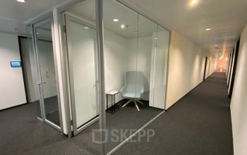 Modernes Büro zur Miete in Am Belvedere 8, 1100 Wien (Favoriten), mit verglasten Wänden und einem Wartebereich mit Sessel.