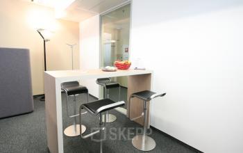 Modern office space rental at Am Euro Platz 2, 1120 Vienna (Meidling), with high stools and a sleek counter for collaborative work.