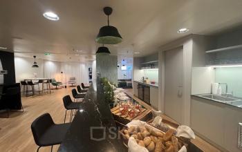Modern office space rental at Am Euro Platz 2, 1120 Vienna Meidling, featuring a well-appointed common area with comfortable seating and a kitchenette.