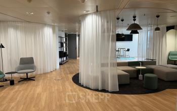 Modern office space rental at Am Euro Platz 2, 1120 Vienna Meidling, with chic furniture and semi-private seating areas.