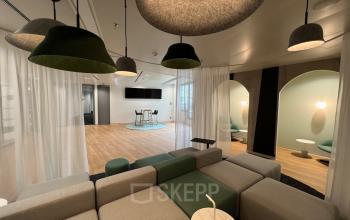 Modern office space rental at Am Euro Platz 2, 1120 Vienna Meidling, featuring a stylish lounge area with cozy seating and chic pendant lighting.