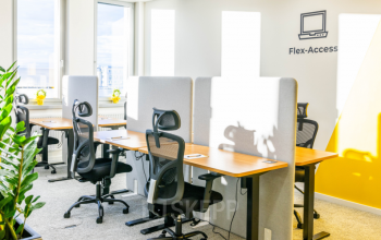 Modern office space rental at Wagenseilgasse 14 in 1120 Vienna Meidling featuring well-lit workspaces with ergonomic chairs and vibrant plant decor.