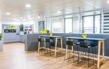 Spacious and well-lit office space rental at Wagenseilgasse 14 in 1120 Vienna Meidling with modern furnishings and a communal kitchen area.