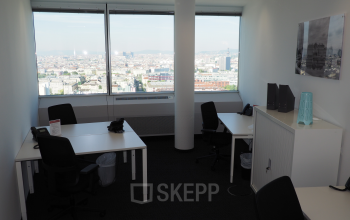 Bright office space rental at Handelskai 94-96, 1200 Vienna with cityscape view, modern desks, and ergonomic chairs.