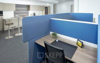 Interior office to rent at Floridsdorfer Hauptstraße 1, 1210 Vienna, featuring workspaces with blue partitions and a kitchenette area.