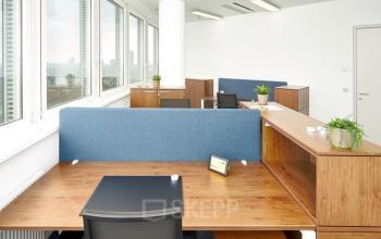 Bright office space with wooden desks and partitions, located at Floridsdorfer Hauptstraße 1, 1210 Vienna. Suitable for office space rental.