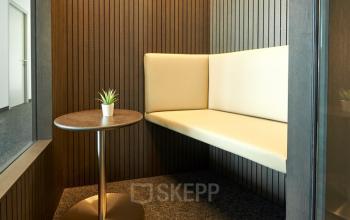 Modern office space rental in Floridsdorfer Hauptstraße 1, 1210 Vienna with stylish seating and a small table, ideal for meetings or break time.