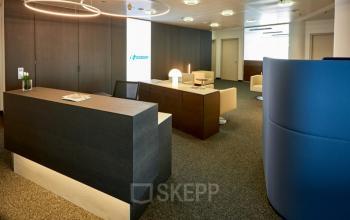 Reception area of an office space rental at Floridsdorfer Hauptstraße 1, 1210 Vienna, featuring a modern desk, cozy seating, and stylish lighting.