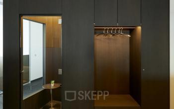 Interior view of an office space with dark wooden panels and a small table at Floridsdorfer Hauptstraße 1 in 1210 Vienna. Office space rental available.