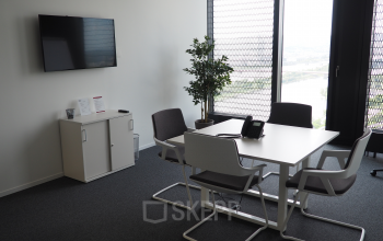 Modern office space rental at Donau-City-Straße 7, 1220 Vienna with a neat meeting area, expansive view, and contemporary furniture.
