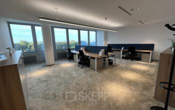 Spacious and well-lit office with large windows, located at Wagramer Straße 19, 1220 Vienna, featuring modern furnishings and multiple desks ideal for office space rental.