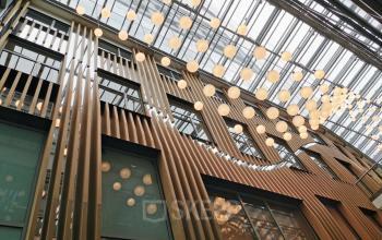 Modern office space rental at Wagramer Straße 19, in Vienna's bustling 1220 Donaustadt district, featuring a stylish interior with hanging lights and wooden accents.