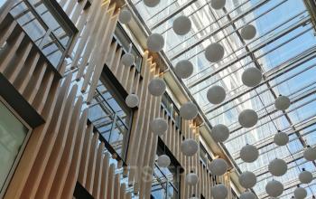 Modern office space rental at Wagramer Straße 19, with a striking glass ceiling and stylish wooden accents.
