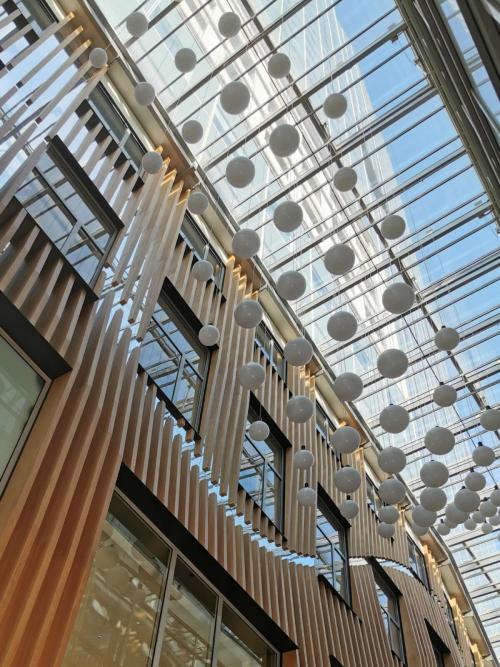 Modern office space rental at Wagramer Straße 19, with a striking glass ceiling and stylish wooden accents.