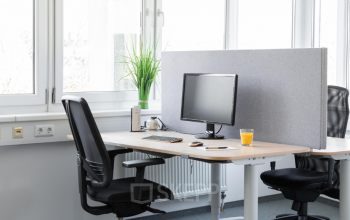 Modern gestalteter Büroraum mit Holztisch, Stühlen und Technik zur produktiven Arbeit in der Anton-Baumgartner-Straße 125, 1230 Wien-Liesing.