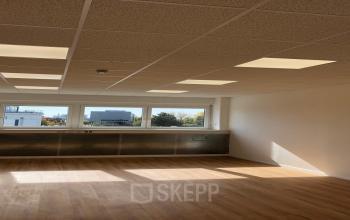 Natural light floods the spacious interior of an office space rental at IZ NÖ Süd Straße 3, 2351 Vienna Neudorf, showcasing a clean and modern work area.