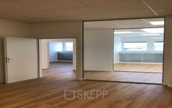 Modern office space rental at IZ NÖ Süd Straße 3, 2351 Vienna Neudorf, featuring a clear view through glass partitions.