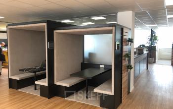 Modern, enclosed pod-style workspaces in the office space rental at IZ NÖ Süd Straße 3, 2351 Vienna (Neudorf), with business professionals in discussion.