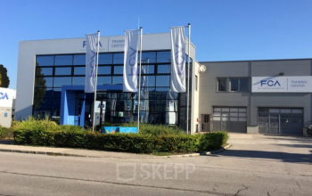 Modern façade of office space rental at Ricoweg 32, in the bustling 2351 Vienna Neudorf area, with clear blue skies and ample parking.