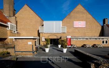 Exterior view of office building located at van Cleeffkade 15, Aalsmeer, Aalsmeer, showing brick architecture and main entrance with directional signs.