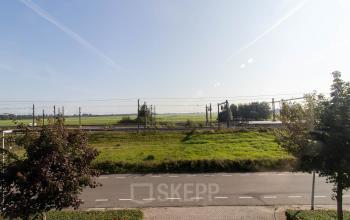 Exterior view from Hollandse Kade 38 in Abcoude, showcasing picturesque greenery and nearby railway tracks, ideal for anyone seeking office space rental with scenic surroundings.
