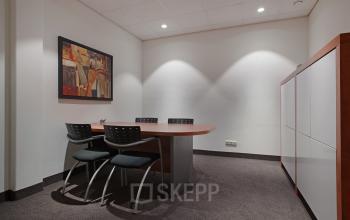 Interior of a furnished conference room in the office space at Twentepoort Oost 61, Almelo, featuring a meeting table with chairs and a storage unit.