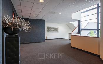 Spacious office interior at Twentepoort Oost 61, Almelo, featuring modern design with large windows and decorative elements showcasing available office space rental.