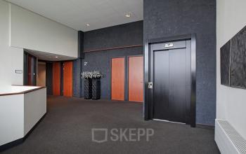 Interior hallway with elevator and multiple doors in an office building at Twentepoort Oost 61, Almelo. Ideal office space rental.