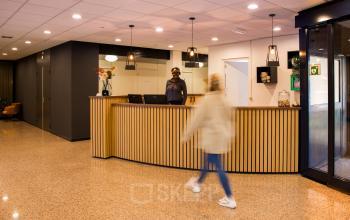 Reception area at Markerkant 1310, Almere Stad, Almere with a front desk, chairs, and modern lighting fixtures, ideal for office space rental.