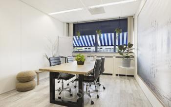 Modern office space rental at Markerkant 1310, Almere Stad, featuring a well-lit room with plants, a desk, and comfortable chairs.