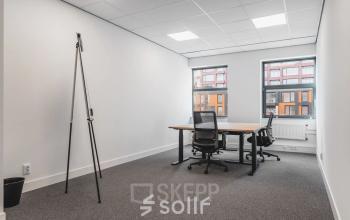 Furnished office space available for rent at Veluwezoom 15, Almere Stad, featuring desks and chairs set against large windows.