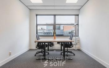Interior office space at Veluwezoom 15 in Almere Stad, featuring a furnished workspace with a large window. Ideal for office space rental opportunities.