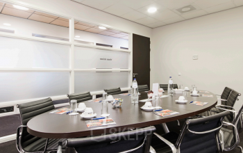 Modern conference room at Leidse Schouw 2, Alphen aan den Rijn, set up with chairs and a table, ideal for office space rental.