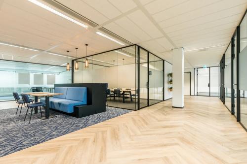 Modern office space at Spoetnik 10-64 in Amersfoort Calveen, featuring stylish furnishings and glass-partitioned meeting areas, available for office space rental.