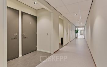 Corridor in Astronaut 28 office building in Amersfoort Calveen, showcasing a clean interior with doors and ceiling lights, ideal for office space rental.