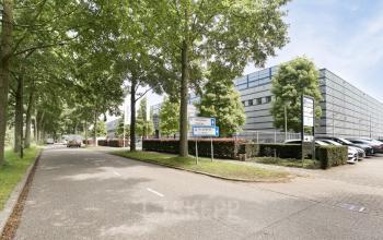 Exterior view of office building at Astronaut 28, Amersfoort Calveen, surrounded by trees and parking spaces. Ideal location for office space rental.