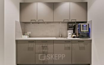 Modern pantry in an office space for rent at Astronaut 28, Amersfoort Calveen; features sleek cabinetry and a coffee machine.